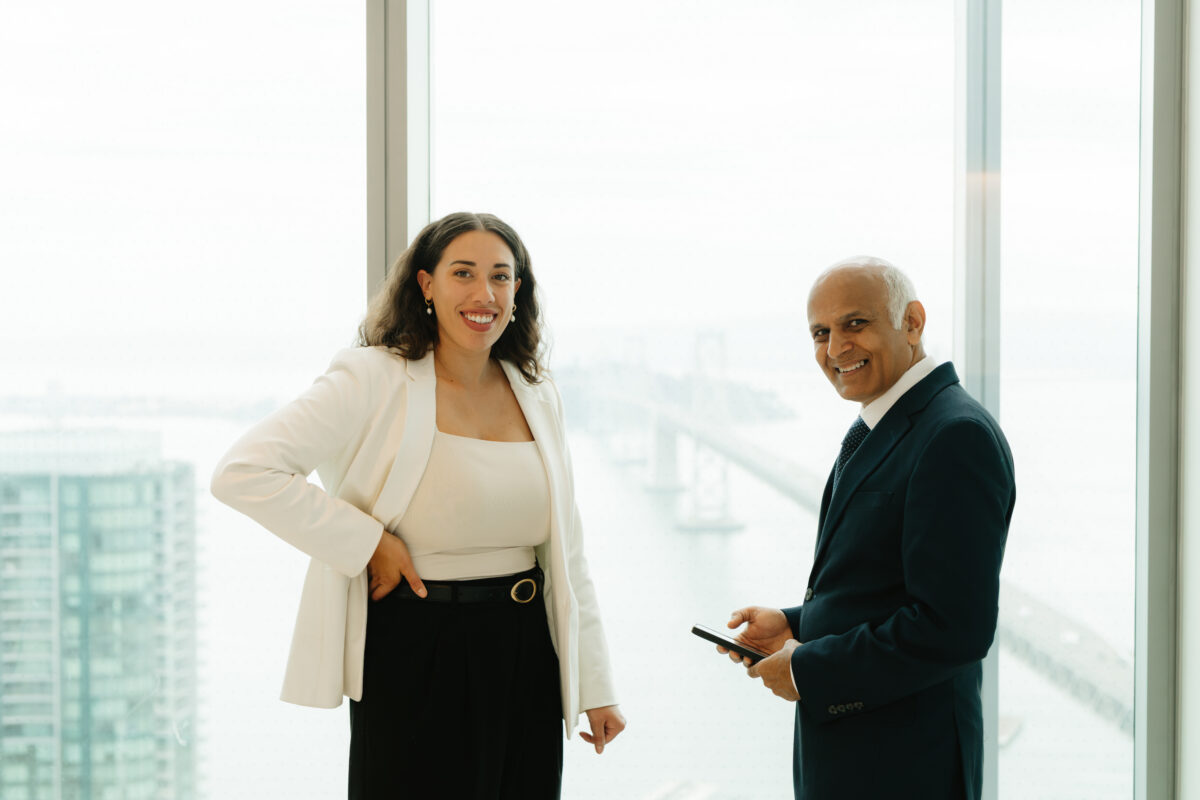 Two advocates smiling while discussing client matters by a window