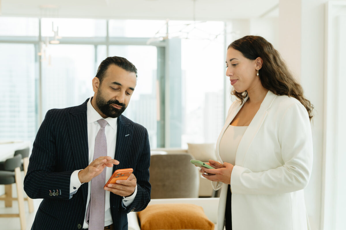 Two legal professionals reviewing case details on smartphones in a modern office0
